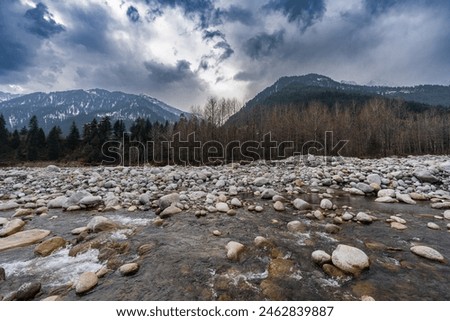 Beas River, with a background of landscape with lakeand  snow-covered mountains, in Manali, Himachal Pradesh, India 