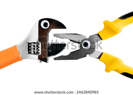 pliers and adjustable wrench facing each other and isolated, cartoonized with plastic eyes and open mouths, white background