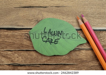 Concept of Lawn Care write on sticky notes isolated on Wooden Table.