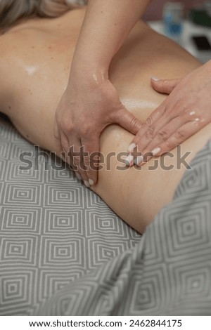 Woman having a therapeutic back massage. Vertical photo. 