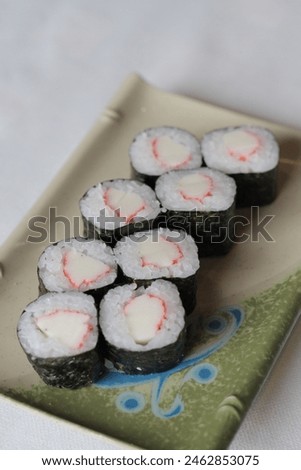 Hosomaki kani: a classic sushi roll featuring tender crab stick wrapped in seasoned rice and nori seaweed, offering a delightful blend of sweetness and brininess in a bite-sized package Royalty-Free Stock Photo #2462853075