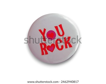 A round white button with the words "you rock" in red, with the 'o' being heart-shaped. Isolated on white background. 