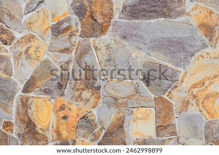 It's a photo of mosaic stones in wall. It is close up view of multicolored stone wall. This is colorful texture for designer. 