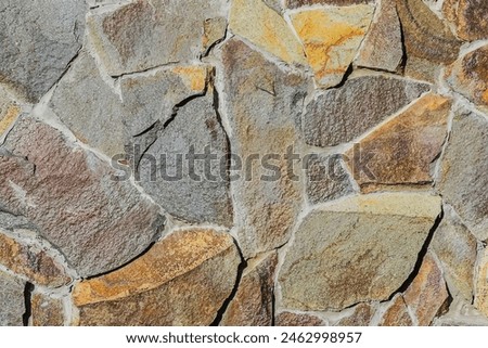 It is close up view of multicolored stone wall.  It's photo of the mosaic stones in wall. This is colorful texture for designer. 