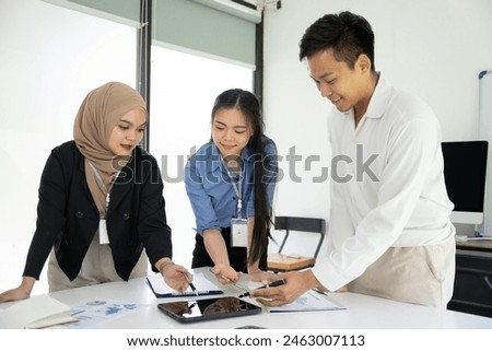 Group of Asian business men and women sitting and looking at documents at the office.
