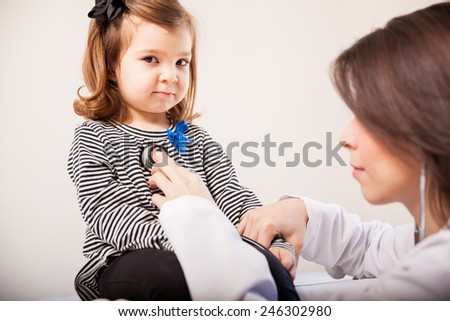Beautiful Latin little girl being examined by a pediatrician in a clinic