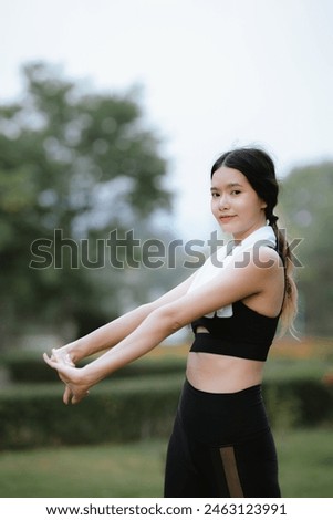 Beautiful Asian female runner doing morning exercise outdoors in city park. smile happily Exercise for good health