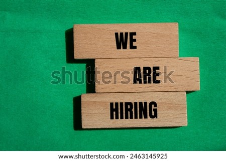 We are hiring words written on wooden block with green background. Conceptual we are hiring symbol. Copy space.