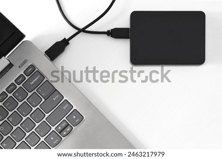 External backup hard disk drive connected to laptop on white background. external hard disk connect by USB 3.0 port to laptop