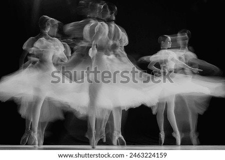 Ghostly silhouettes of ballerinas performing pirouettes on stage. Black and white photo with long exposure. Timeless. Concept of beauty, classic and modernity, contemporary art. Ad