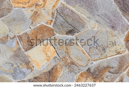 It's photo of mosaic stones in wall. It is close up view of multicolored stone wall. This is colorful texture for the designer. 