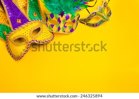 Assorted colorful Mardi Gras mask on yellow background