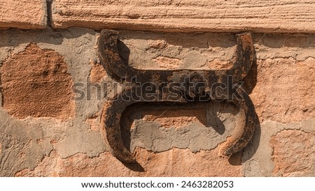 decorative building anchor. Historic architecture. Rusty element of the facade. Bolt and nut. Stone wall.