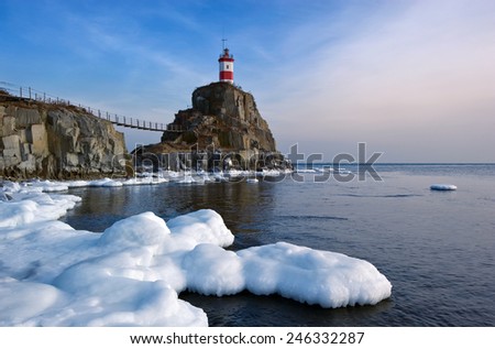 Winter picture lighthouse on a lonely rock.
