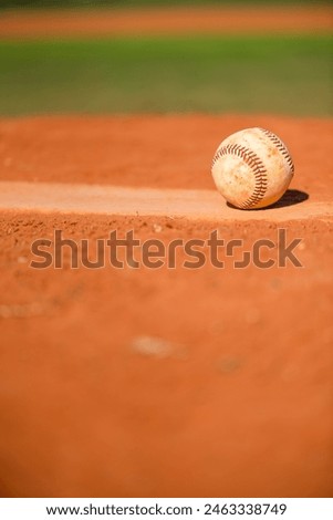Baseball with dirt on it sitting atop pitchers mound close up
