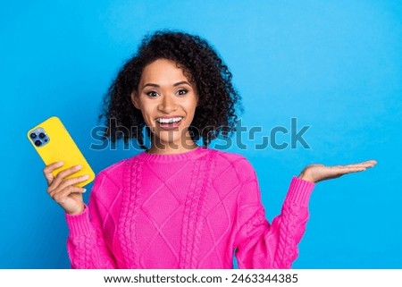 Photo of nice young girl hold smsart phone empty space wear pink sweater isolated on blue color background