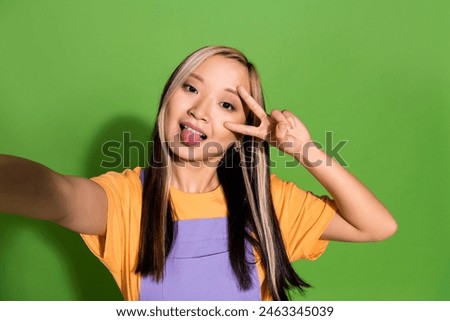 Photo portrait of attractive young woman selfie photo v-sign dressed stylish violet yellow clothes isolated on green color background