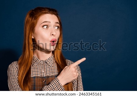 Photo of funky good mood lady lady dressed plaid outfit looking pointing empty space isolated dark blue color background