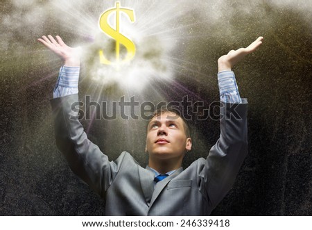Businessman praying at dollar sign above