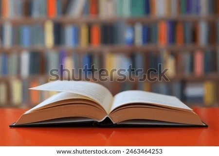 open book on orange table in library