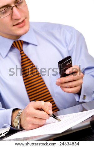 Businessman doing paperwork, looking at cellphone screen