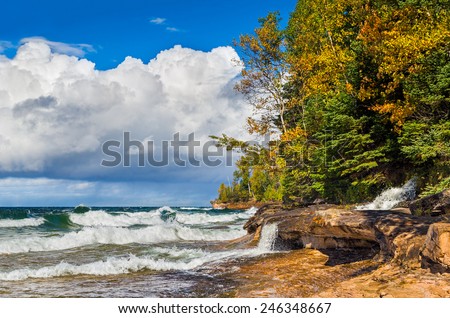 Elliot Falls, a waterfall in Michigan's Pictured Rocks National Lakeshore, cascades into Lake Superior across the rocks of Miner's Beach.