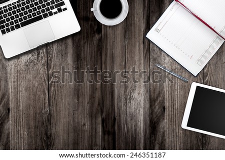 Tablet, notepad, computer and coffee cup on office wooden table Royalty-Free Stock Photo #246351187