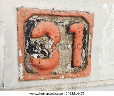 This image showcases a house identity feature displaying the house number "31" crafted from cement, with the numbers designed in a raised 3D style. The house number "31" and its surrounding border are