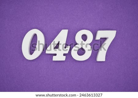 The number 0487 is made from white painted wood. Place it on a purple paper background.