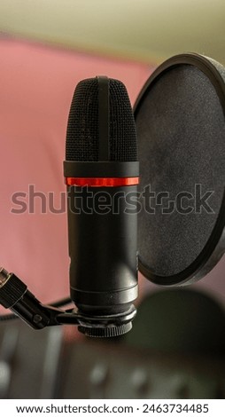 A professional-grade microphone equipped with a pop filter, designed to enhance audio clarity and reduce unwanted noise.