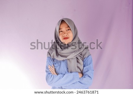 Portrait of an Asian Muslim woman in casual style on an isolated pink background