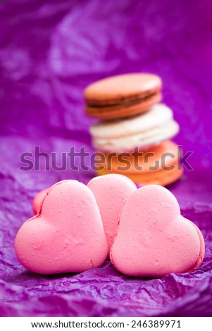 French colorful macarons with hearts on violet background 