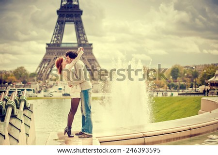 Lovers kissing in Paris with the Eiffel Tower in the Background