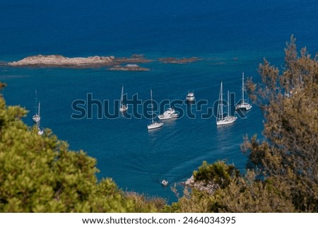 Sailboats at anchor in Corsica. Sailboats floating on the calm blue sea.  Coastal summer landscape. The Gulf of Sagone seen from Cargèse, Corsica, France