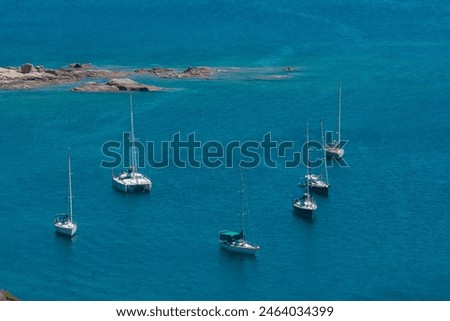 Sailboats at anchor in Corsica. Sailboats floating on the calm blue sea.  Coastal summer landscape. The Gulf of Sagone seen from Cargèse, Corsica, France