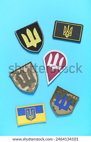 Different military badges of Ukrainian army with trident on blue background