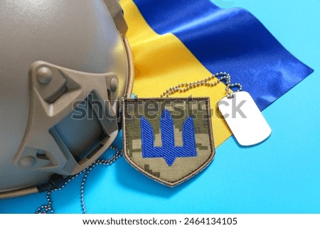 Military badge with trident, tactical helmet and flag of Ukraine on blue background