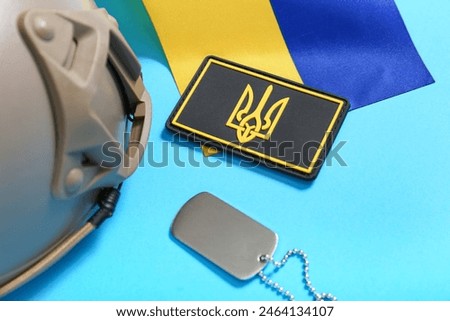 Military badge with trident, tactical helmet and flag of Ukraine on blue background