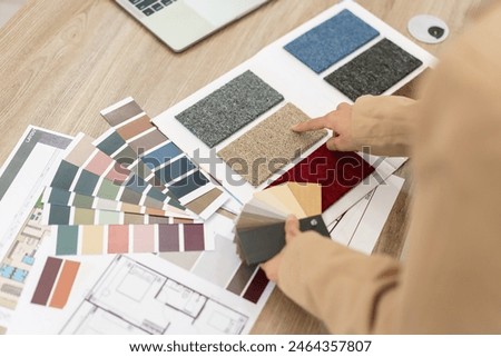 Architectural concept, Female architect choosing color on color swatch for house interior design.