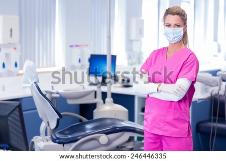 Dentist in surgical mask standing with arms crossed at dental clinic Royalty-Free Stock Photo #246446335