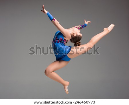 teenager doing gymnastics dance  in  jumping on a gray background