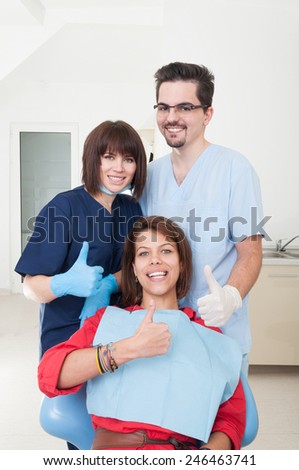 Friendly dental team and patient with thumbs-up
