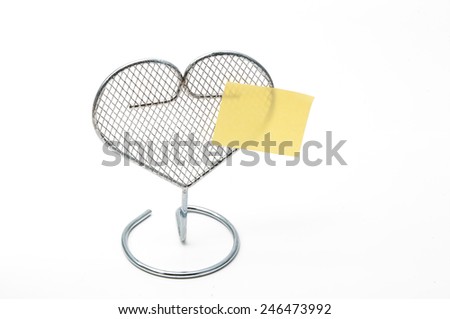 metal grate heart on white background with notepad