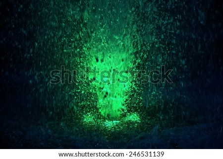 Abstract colorful fountain splashes light green color of water drops on a black background. motion blur