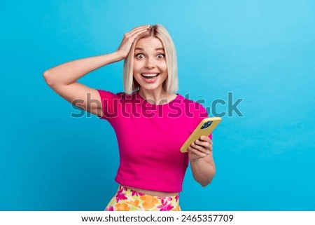 Photo portrait of lovely young lady hold device excited amazed dressed stylish pink clothes isolated on blue color background