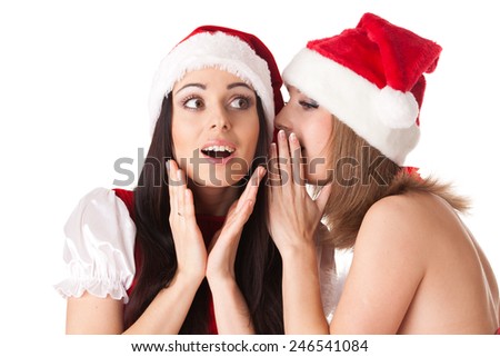Two young women in Santa costume on a white background. Female secrets.