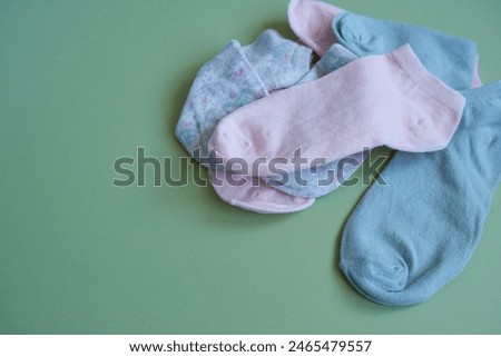 Scattered colorful socks on a light green background.