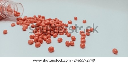 Orange masterbatch granules isolated on a white background for industrial plastic product catalog banner design