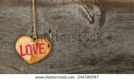 Love Valentines message wooden heart sign from recycled old palette on rough grey wood background, copy space
