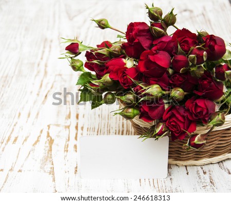 Basket with red roses on a wooden  background